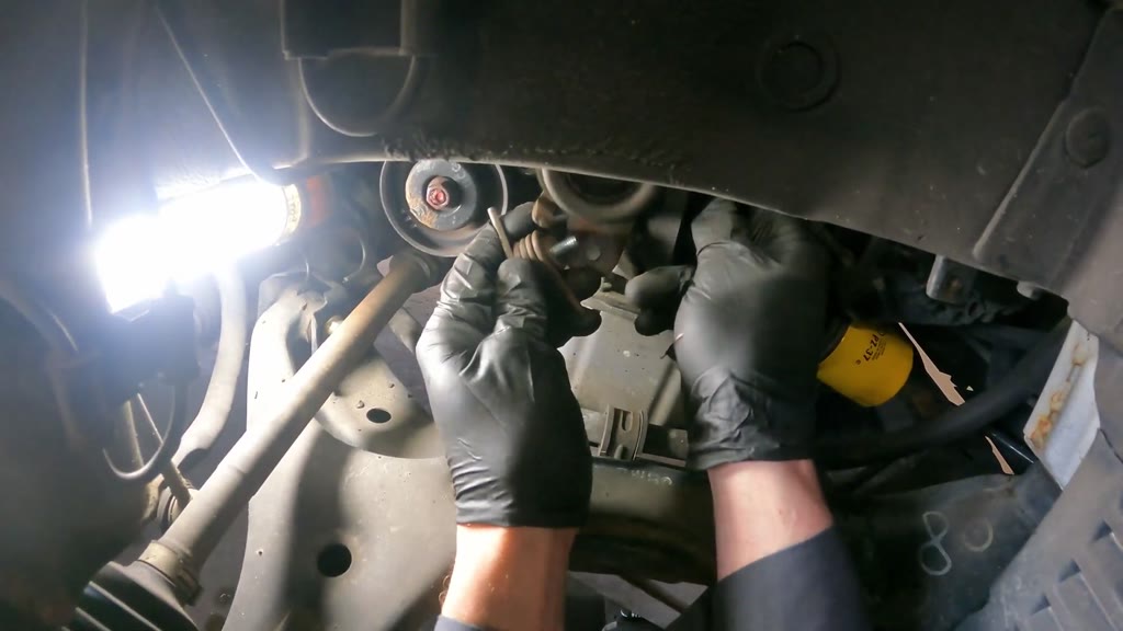 Step 15: Remove the timing-belt tensioner and spring