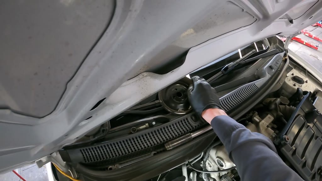 The mechanic moved the removed accessory pulleys and belts onto the windshield cowl in several separate handling actions